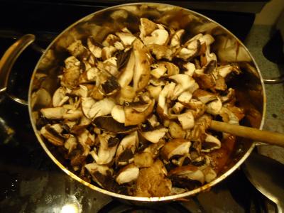 Ground beef & mushrooms in a pan cooking on the stove.